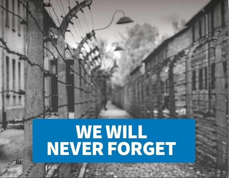We Will Never Forget Holocaust memorial with barbed wire and a 'We Will Never Forget' message.