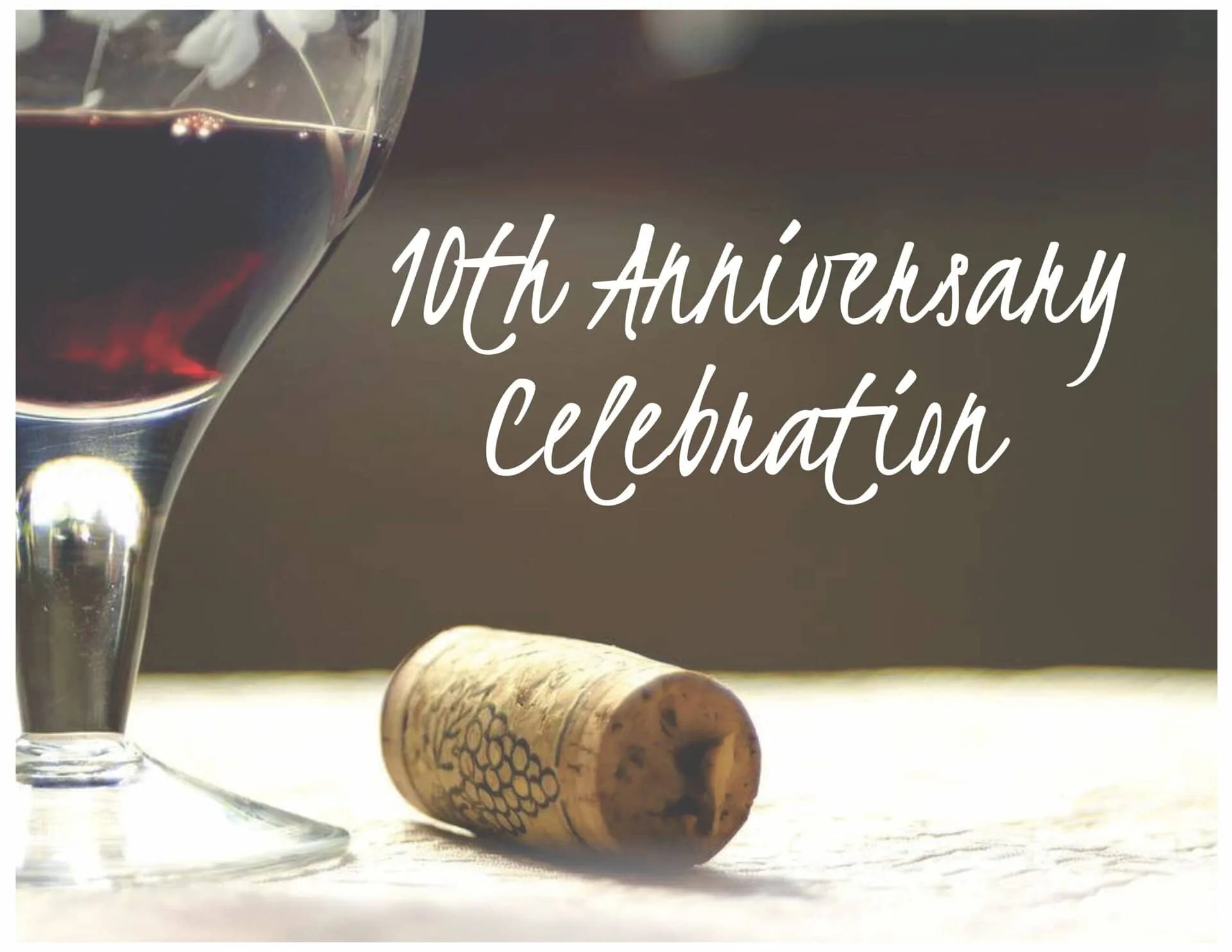Theology Uncorked 10th Celebrating 10th anniversary with wine and cork on table.